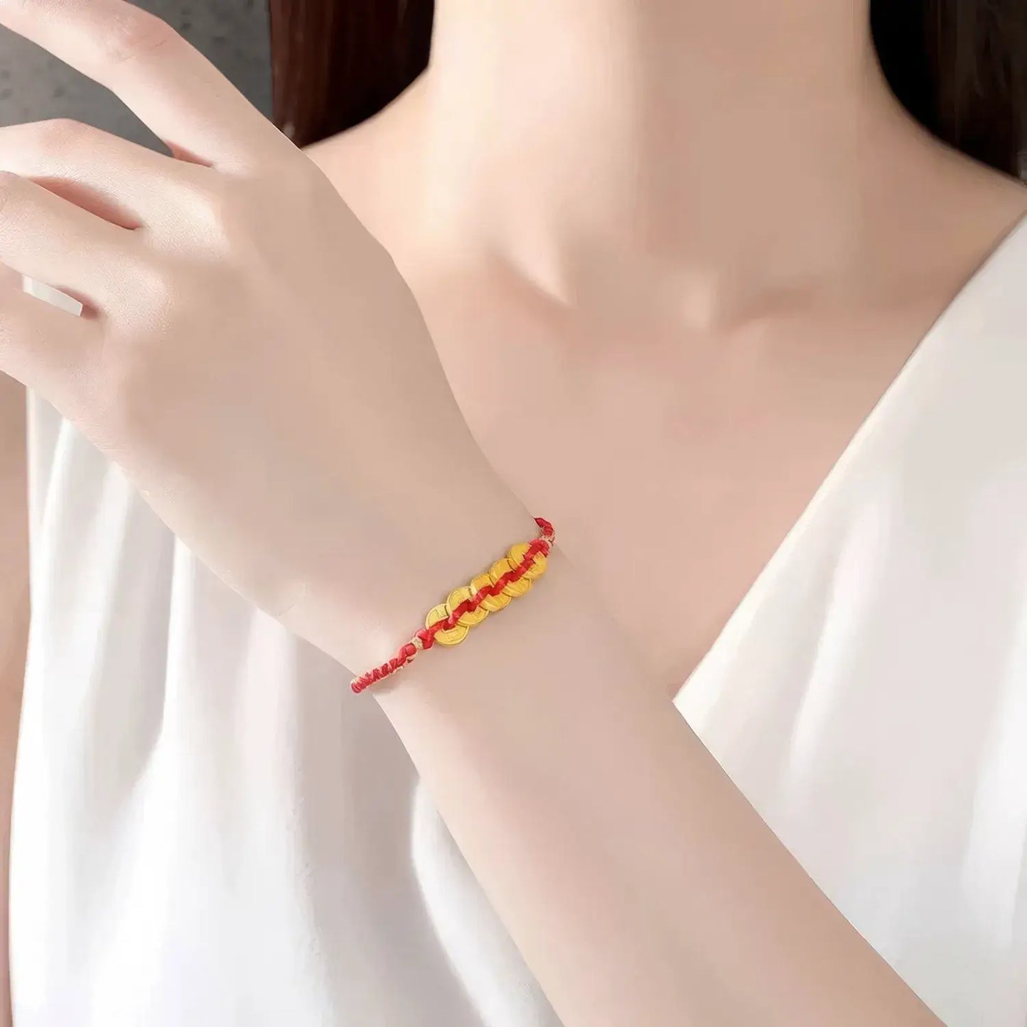 Bracelet with red and yellow beads on a person's wrist against a white background
