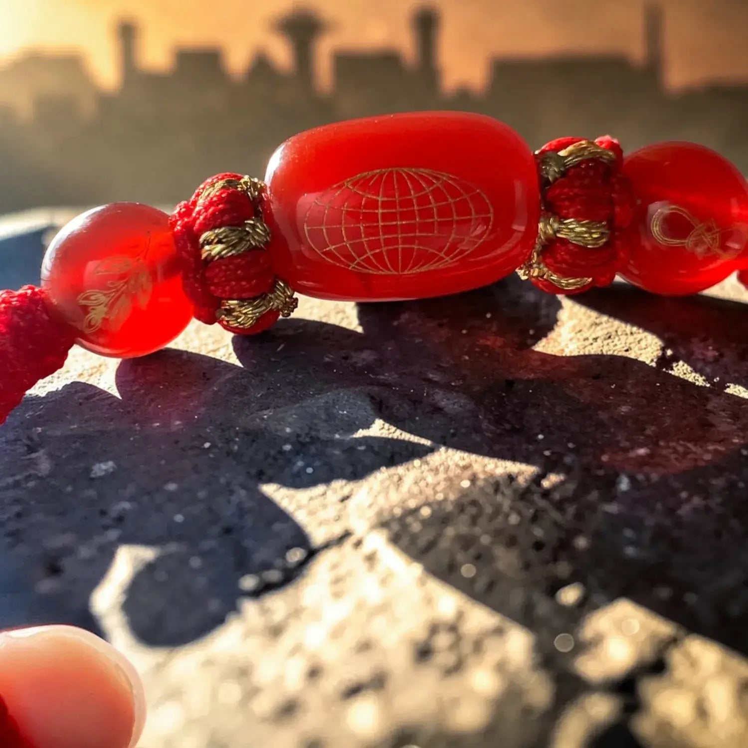 Close-up of a red beaded bracelet with a blurred background