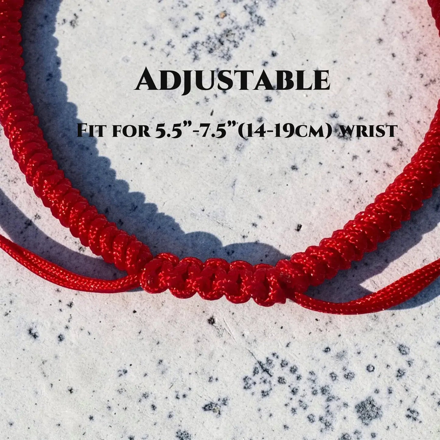 Red adjustable bracelet on a textured white background with text indicating size.