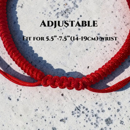 Red adjustable bracelet on a textured white background with text indicating size.