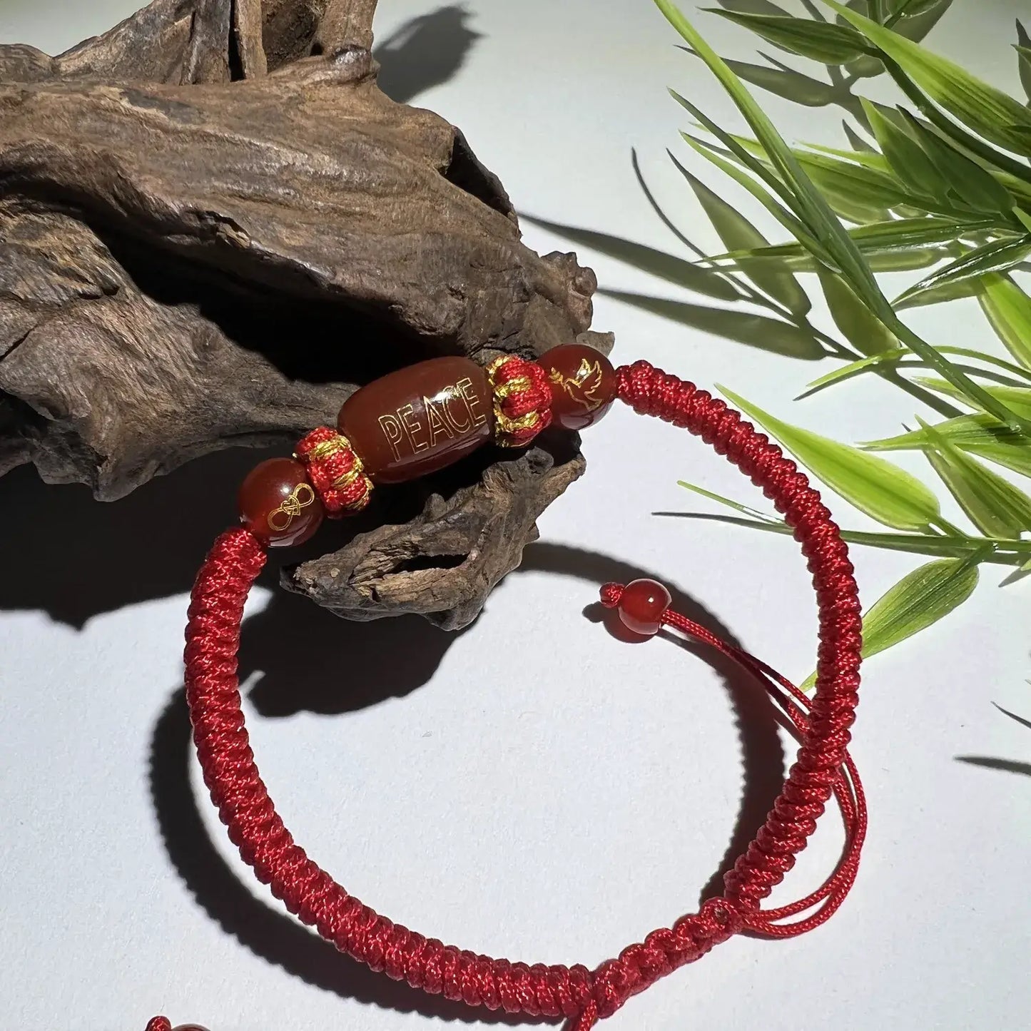 Red string bracelet with beads on a natural background