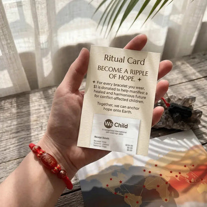 Hand holding a 'Ritual Card' with a scenic background