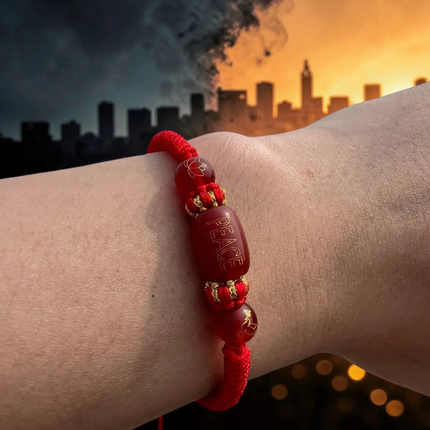 Red bracelet with 'PEACE' beads on a wrist against a cityscape background